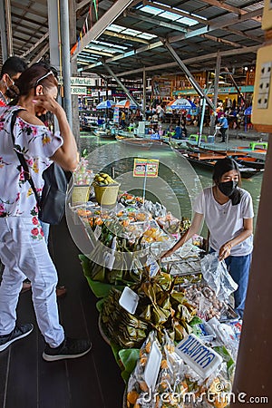 Floating water market in Ratchaburi, Thailand selling fruit and vegetables from their boats. Editorial Stock Photo
