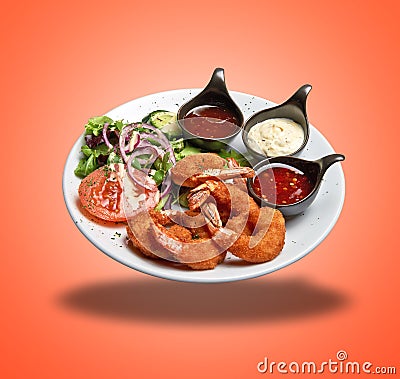 Floating White plate with roasted shrimps, sausage and salad Stock Photo