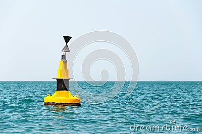 Floating yellow buoy on blue sea Stock Photo