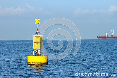 Floating yellow navigational buoy on blue sea Stock Photo