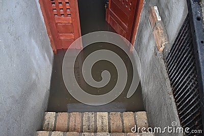 Flooded basement after the massive rain. Flooded cellar with wooden door full of dirty water Stock Photo