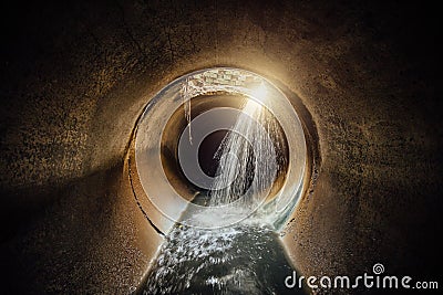 Flooded round sewer tunnel with water reflection Stock Photo