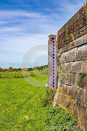 Floodplain in Maas river with a hydrometric metric scale next to a wall Stock Photo