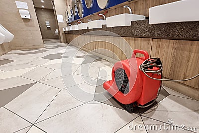 Floor dryer fan used in public washroom and toilet to dry the floor after washing and cleaning Stock Photo