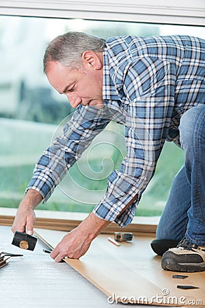 Floor installer using hammer Stock Photo
