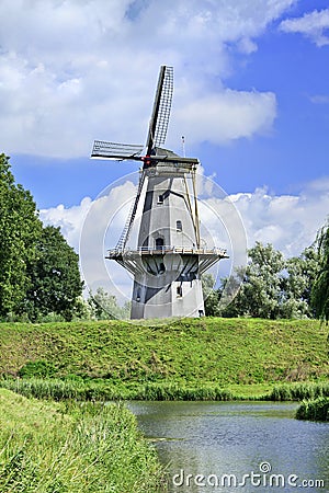 Floor mill build on a city wall with a blue sky and dramatic clouds, Netherlands Stock Photo