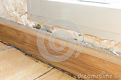 Floor moldings and paint color swelling on old white wall Stock Photo