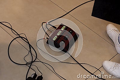 Guitar pedal control. On the floor. There`s a guitarist nearby. We`ve had his legs in sneakers and wires Stock Photo