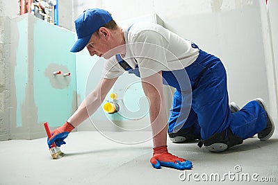 Floor waterproofing in bathroom. Worker adding Ñ†ater resistant, protective coating Stock Photo