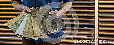 Flooring store seller with vinyl floor samples in hands. copy space Stock Photo