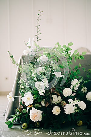 Floral arrangement of white delicate flowers and fresh greenery in the design of the wedding table of the bride and groom in white Stock Photo