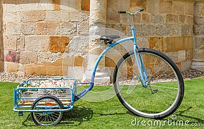 Floral decoration for celebrating an outdoor party with a bicycle, vintage blue tricycle in the garden. Editorial Stock Photo