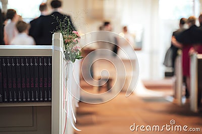 Floral decoration. Pink flower and lush green leaves with white ribbon. Decorated indoor space in church. Wedding day Stock Photo