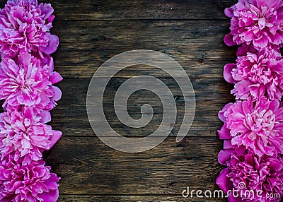Floral frame with pink peonies flowers on wood background. Selective focus, place for text, top view Stock Photo