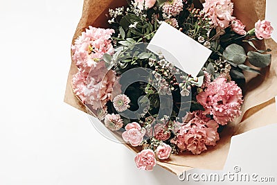 Floral wedding, birthday mockup. Blank business card, invitatio. Pink floral bouquet in craft paper isolated on white Stock Photo