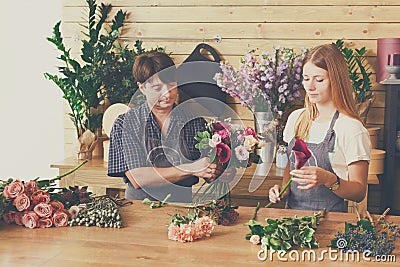 Florist and assistant in flower shop delivery make rose bouquet Stock Photo