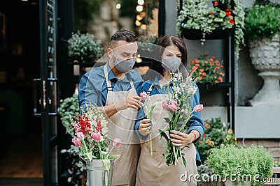 Florist collects bouquet of different flowers. Millennial designers man and woman decorate composition Stock Photo