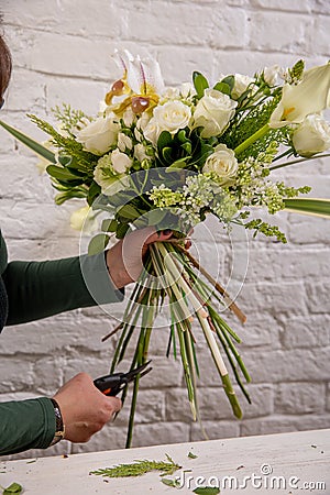 The florist creates a floral arrangement of roses, lilacs, callas, carnations, hydrangeas, brasica, alstroemeria, ornithogalum, Stock Photo