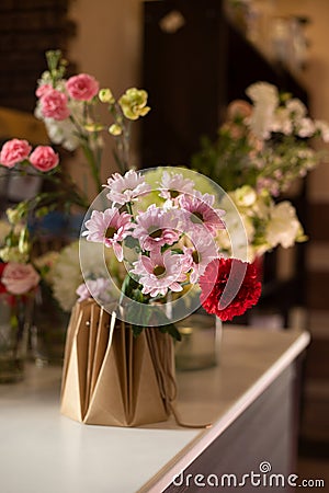 The florist creates a red beautiful bouquet of mixed flowers. Flower shop. Fresh bouquet. Master classes Stock Photo