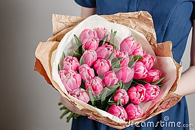 Florist girl with peony flowers or pink tulips Young woman flower bouquet for birthday mother's day. Stock Photo