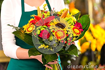 Florist holding bouquet colorful flowers shop assistant Stock Photo