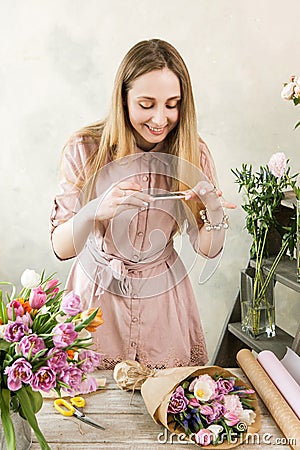 Florist photographing bouquet at phone Stock Photo