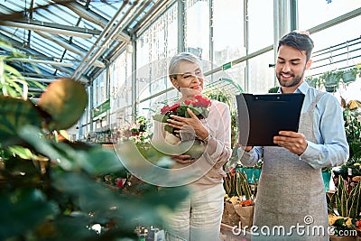 florist seller is making a purchase in his store. Stock Photo
