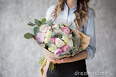 Florist at work: pretty young woman making fashion modern bouquet of different flowers Stock Photo