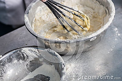 Flour and bread batter inside steel bowl on stainless Stock Photo