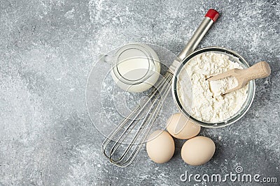Flour, eggs, milk and whisker on marble background Stock Photo