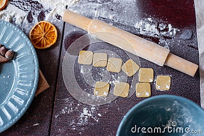 Flour is scattered on wooden Christmas table, gingerbread cookies are being baked. New Years flatlay Stock Photo