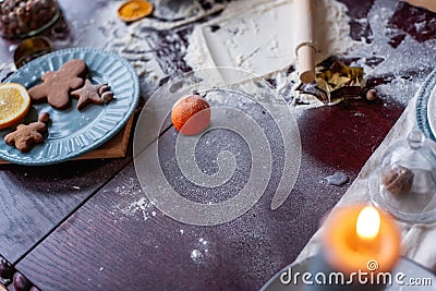 Flour is scattered on wooden Christmas table, gingerbread cookies are being baked. New Years flatlay Stock Photo