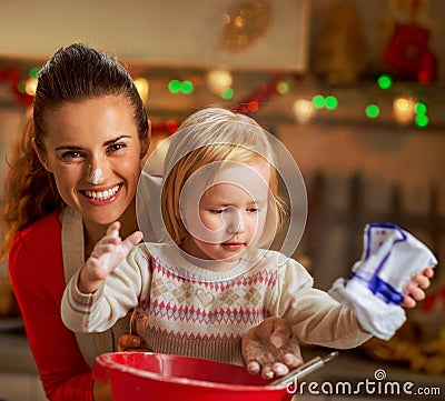 Flour smeared mother and baby making christmas cooki Stock Photo