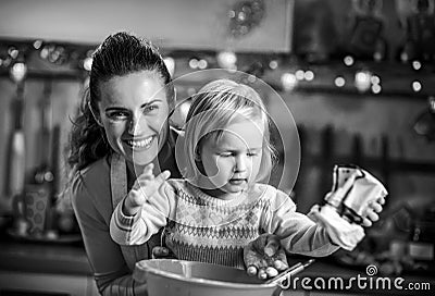 Flour smeared mother and baby making christmas cooki Stock Photo