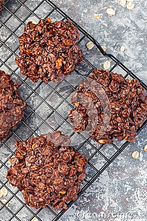 Flourless no bake peanut butter and oatmeal chocolate cookies on a cooling rack, vertical, top view Stock Photo