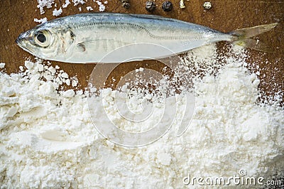 Floury fish on a wooden background Stock Photo