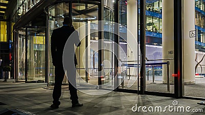 The flow of people passing through the revolving door of the modern office building at the end of the working day Editorial Stock Photo