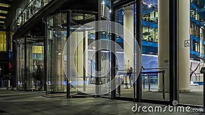 The flow of people passing through the revolving door of the modern office building at the end of the working day Editorial Stock Photo