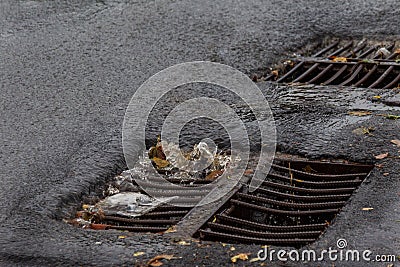 Flow of water during heavy rain and clogging of street sewage. The flow of water during a strong hurricane in storm sewers. Sewage Stock Photo