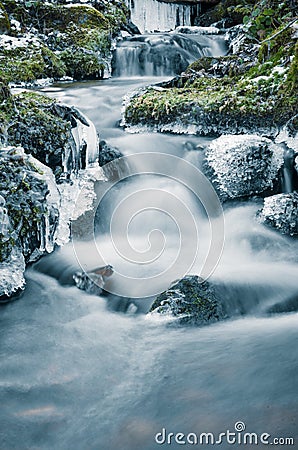 Flow of water in the spring of icicles and ice Stock Photo