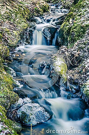 Flow of water in the spring of icicles and ice Stock Photo