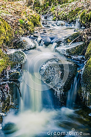 Flow of water in the spring of icicles and ice Stock Photo