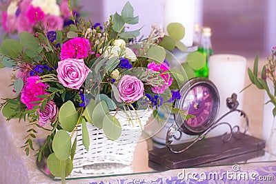 Flower arrangement in a basket decorate the wedding table in purple tones. Vintage. Stock Photo