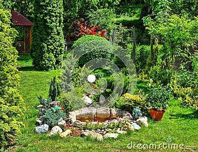 Flower garden and artesian fountain in the yard Stock Photo