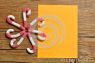 A flower pattern made out of candy canes with an empty orange note pad Stock Photo