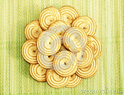Orange beige colour bright cookies are arranged like a flower on a green yellow beach mat Stock Photo