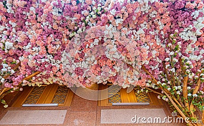 Flower tree encircled building. Solid background of red and white flowers Stock Photo