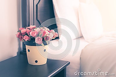 Flower vase on night table in bedroom, vintage style image. Stock Photo