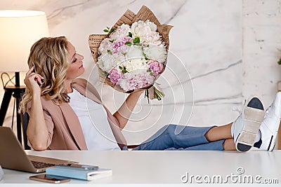Flowers as a gift, Flower delivery. A young woman with a beautiful bouquet of peonies Stock Photo