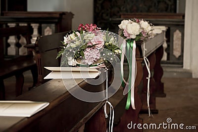 Flowers and booklets on church bench for wedding Stock Photo